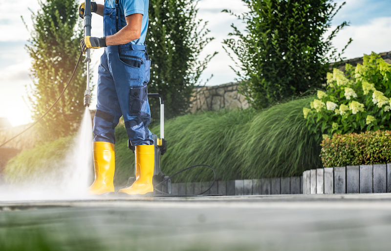 Caucasian Garden Worker Pressure Washing Residential Driveway