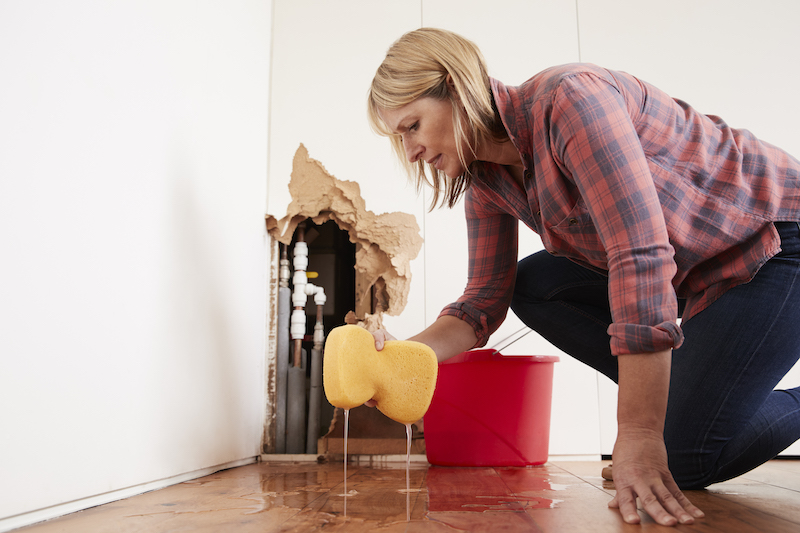 Worried woman mopping up water